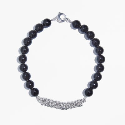 Crane Necklace featuring jet black onyx beads and handwoven solid 925 sterling silver Byzantine chainmail on a white background